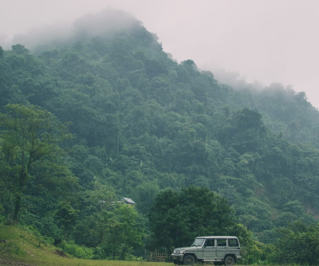 A vertical shot of mountains covered in greenery and a car - perfect for mobile